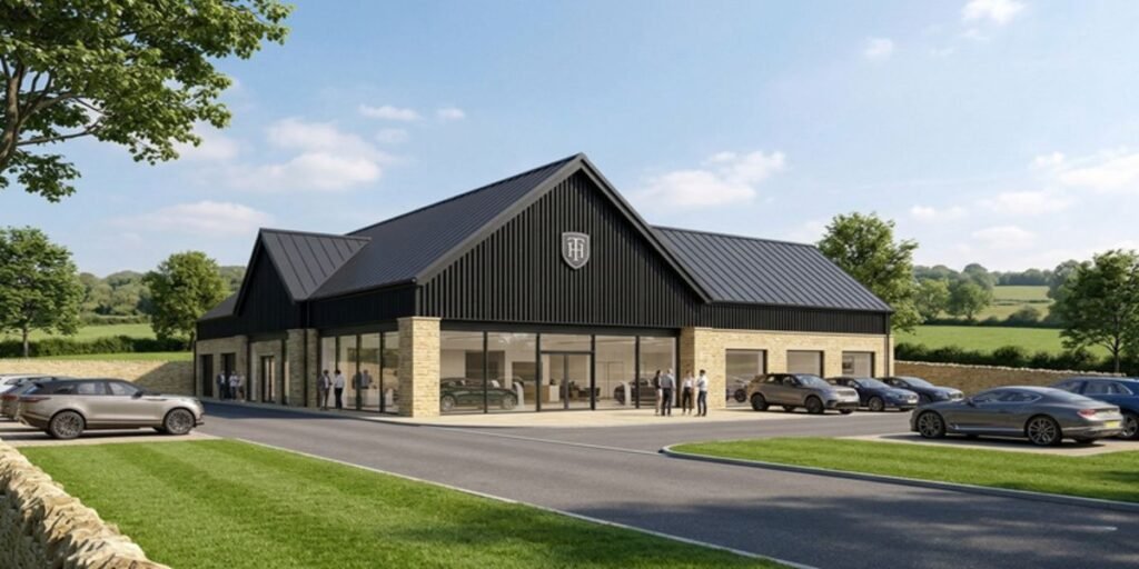 High-end architectural rendering of the new Tom Hartley Jnr independent luxury car dealership in Hook Norton, Oxfordshire, showing contemporary barn-style buildings with dark vertical cladding and manicured grounds.